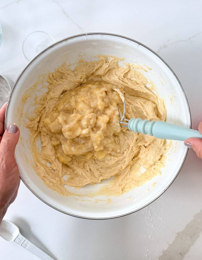 adding bananas to the cake batter