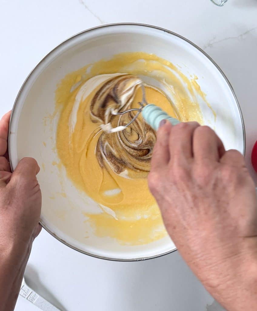 adding vanilla and sour cream to the cake batter