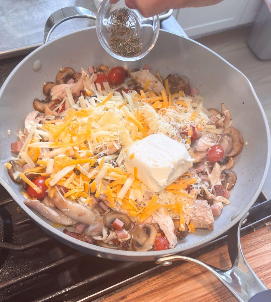 adding cheeses and pasta water to skillet