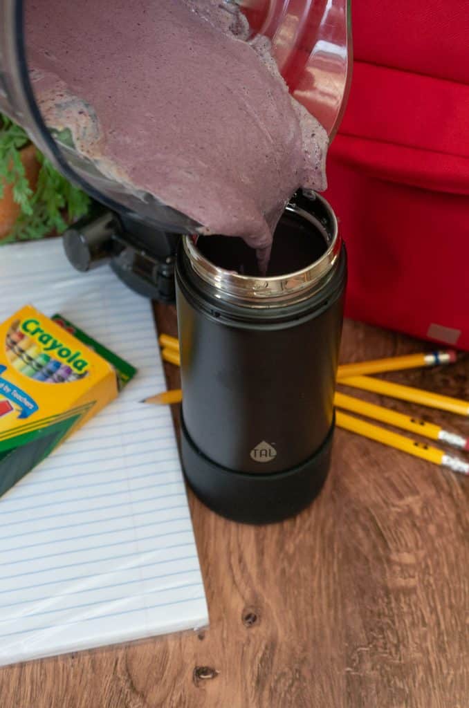 pouring smoothie into the thermos 