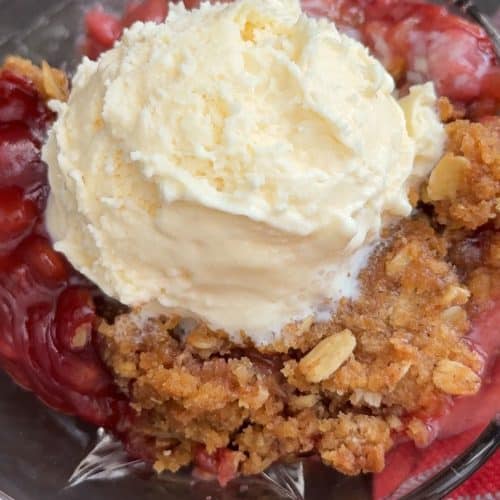 bowl of crisp with a scoop of vanilla ice cream on top