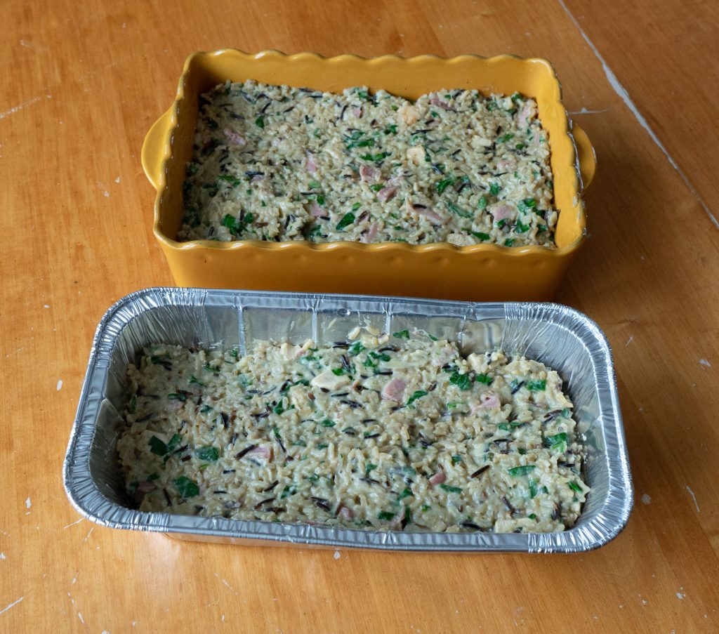 pan of chicken fontinella and a aluminum pan with chicken fontinella on a table