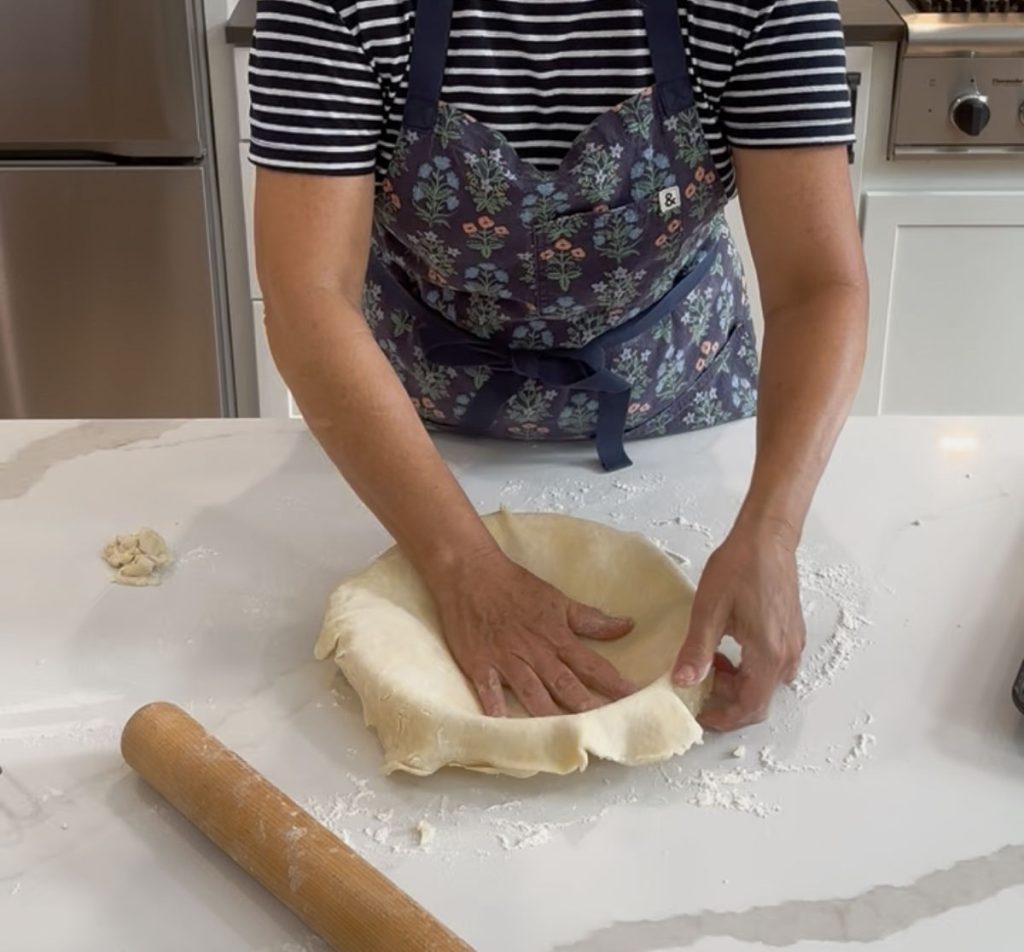 forming bottom pie crust into glass pie plate