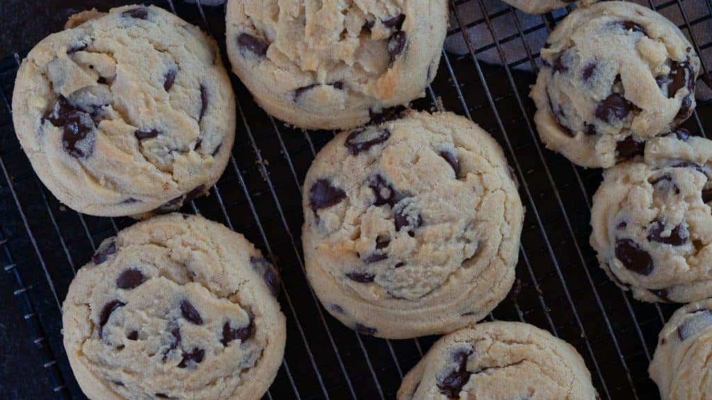 baked melt in your mouth chocolate chip cookies on a cooling rack