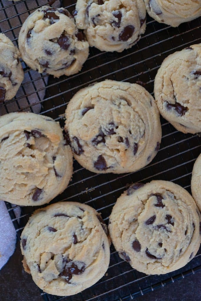 two sizes of chocolate chip cookies cooling on a cooling rack