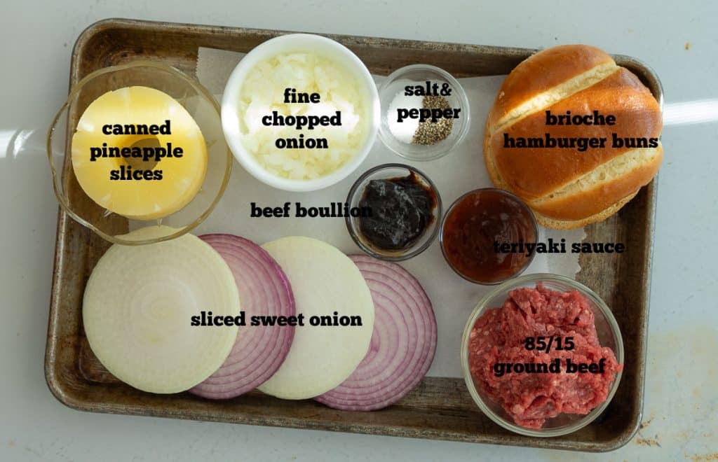 ingredients for hawaiian burgers on a baking sheet on a white countertop