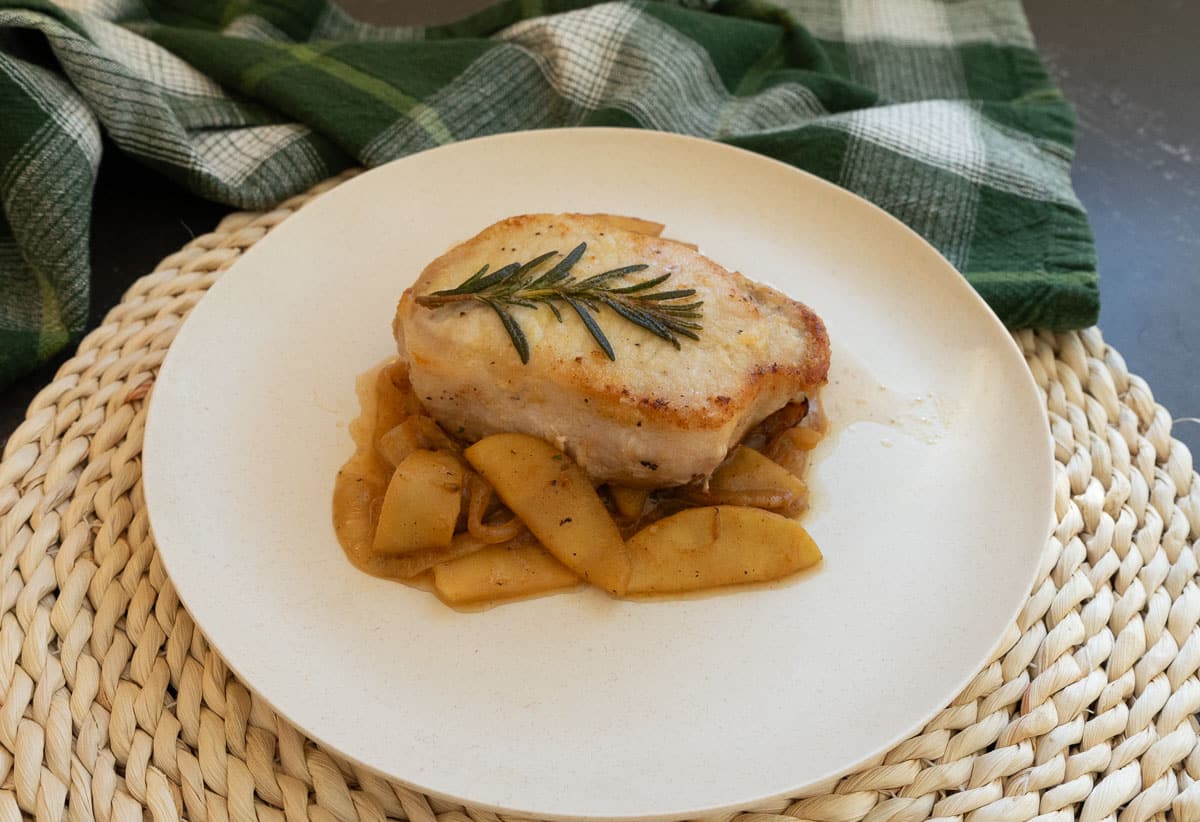 Thick cut pork chops over caramelized onions with apples and rosemary