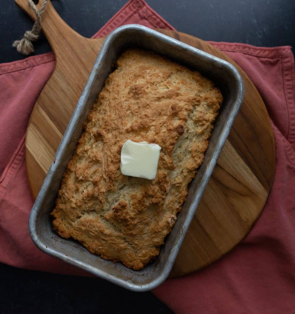 baked beer bread with a pat of butter sitting on the top