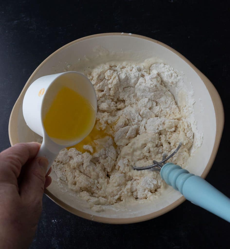 pouring melted butter into the bowl with the beer bread batter
