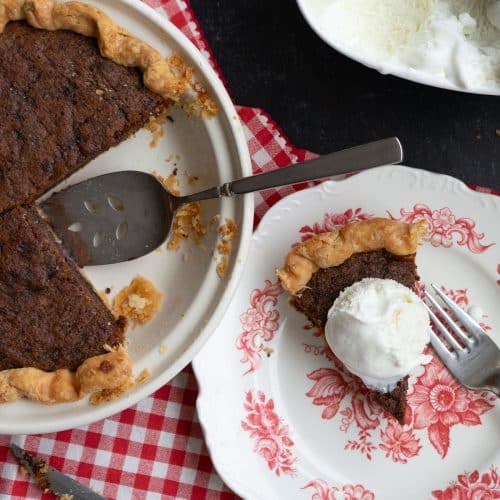 toll house cookie pie with a piece removed beside a piece of toll house cookie pie on a dessert plate with ice cream on top
