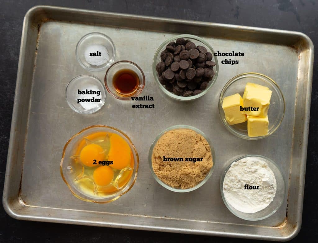 The ingredients for toll house cookie pie on a baking sheet.