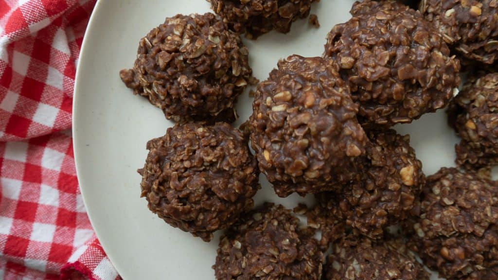 no bake cookies on a tan colored plate that is sitting on a red and white checked cloth