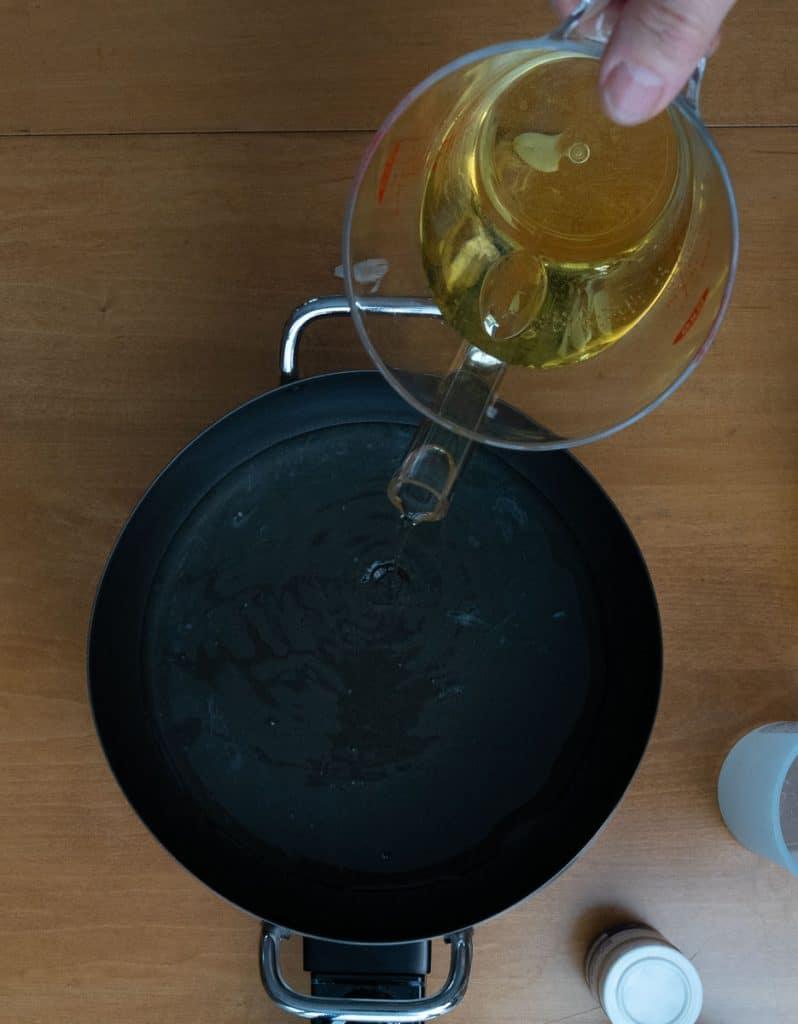pouring white wine and lemon juice in to the warm fondue pot