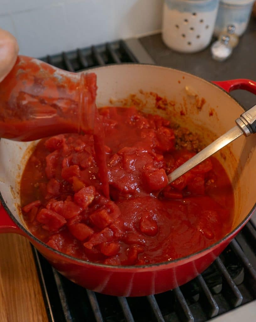 adding all the tomato sauce, puree, paste and diced tomatoes to the browned meat