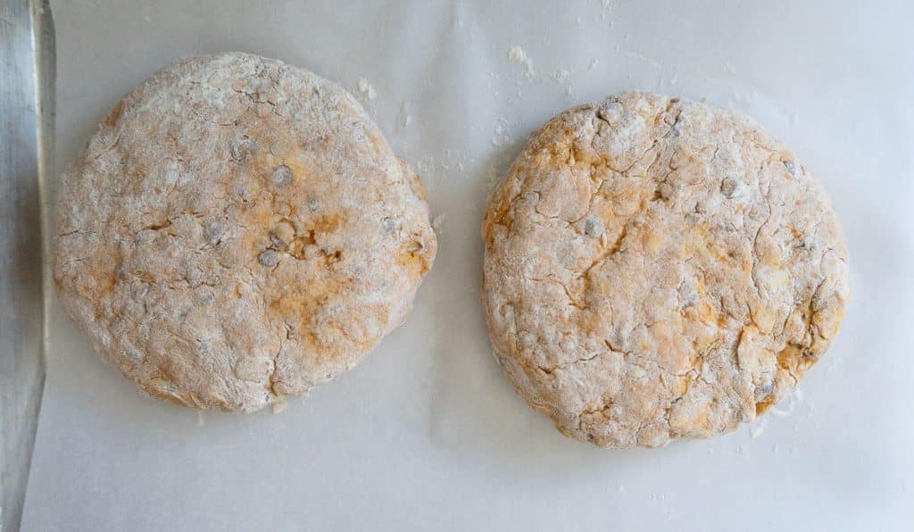 two scone rounds on a parchment lined baking sheet