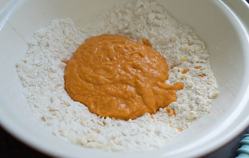 pumpkin and buttermilk mixture in the middle of dry ingredients in a large bowl
