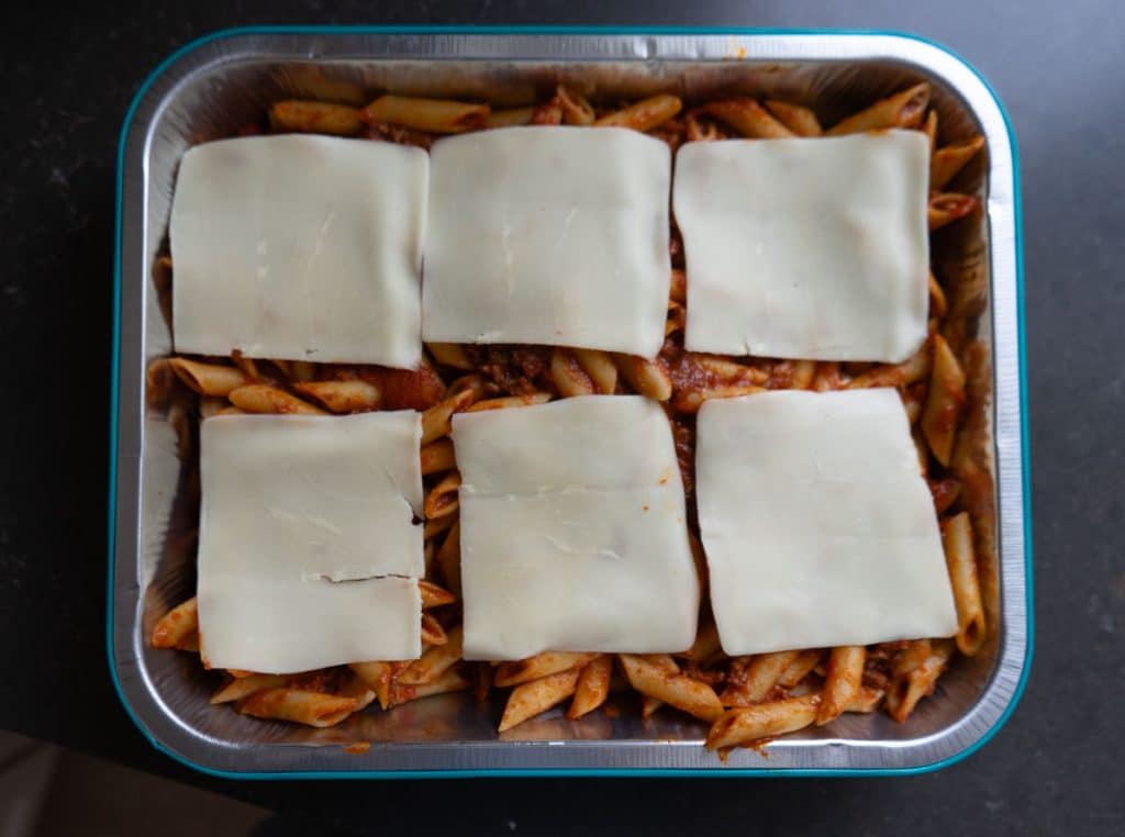 mostaccioli in pan before baking it with slices of mozzarella on top