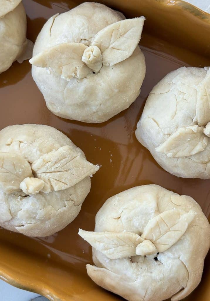 apple dumplings in baking dish before being baked