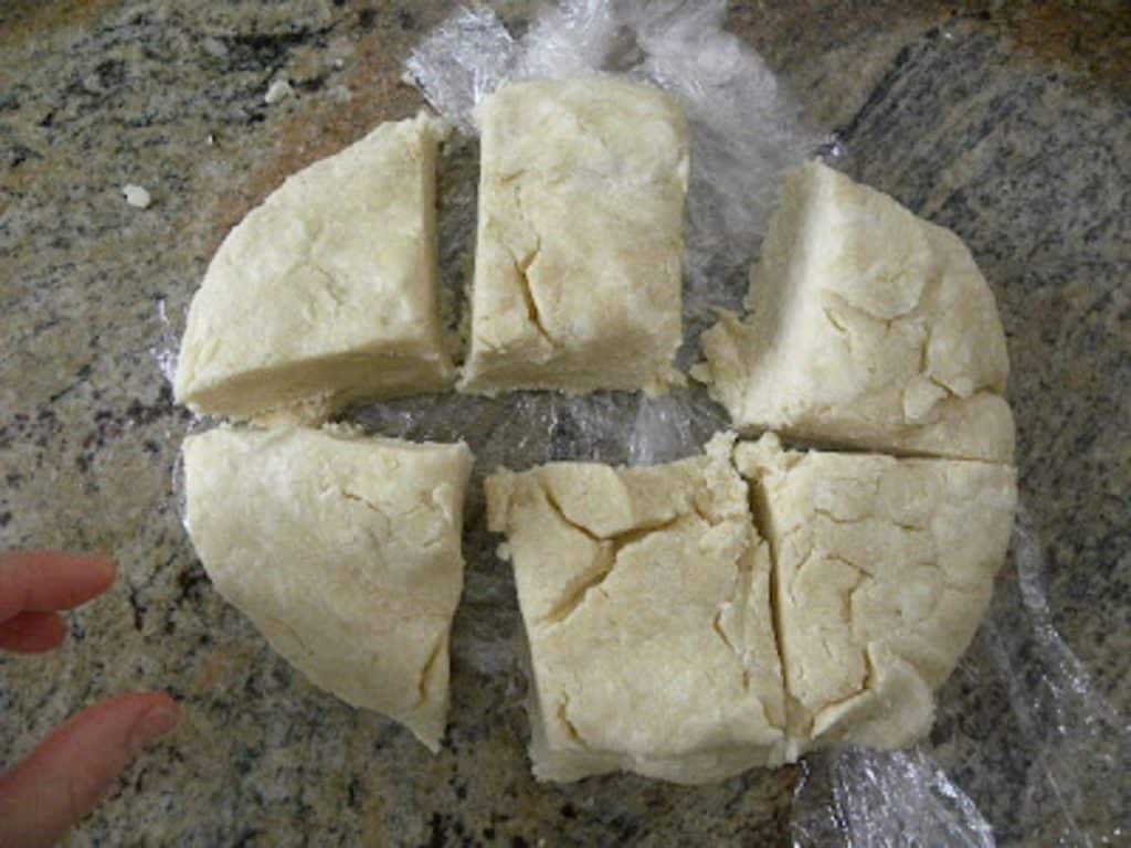 pastry dough for the apple dumplings divided into 6 pieces on kitchen countertop