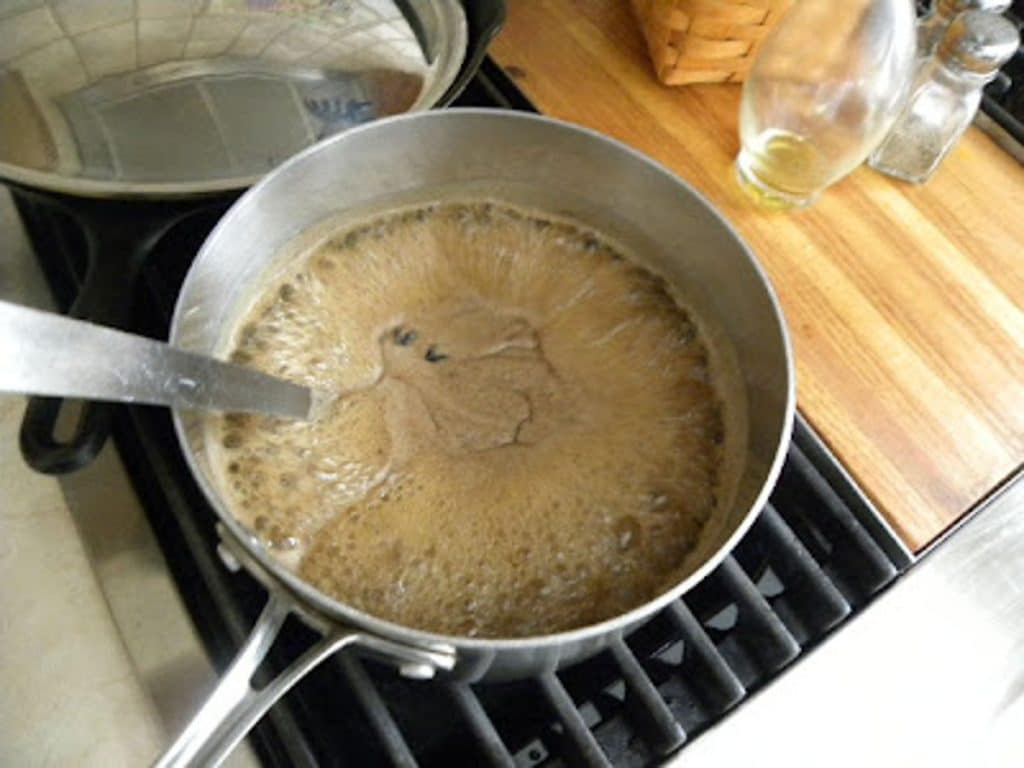 apple dumpling syrup cooking in a saucepan on the stove top