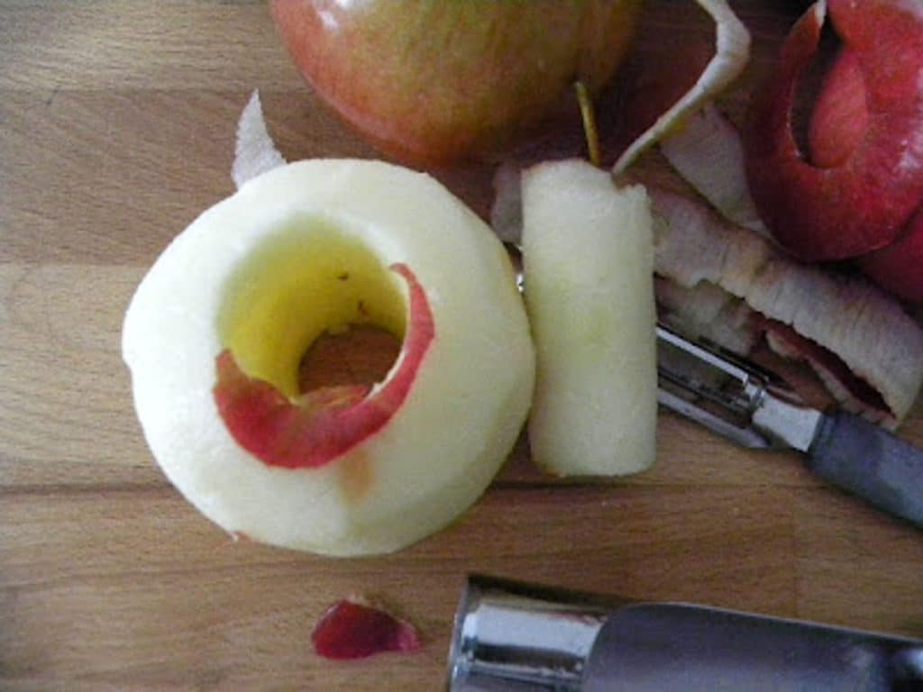 peeled and cored apple on a wood cutting board