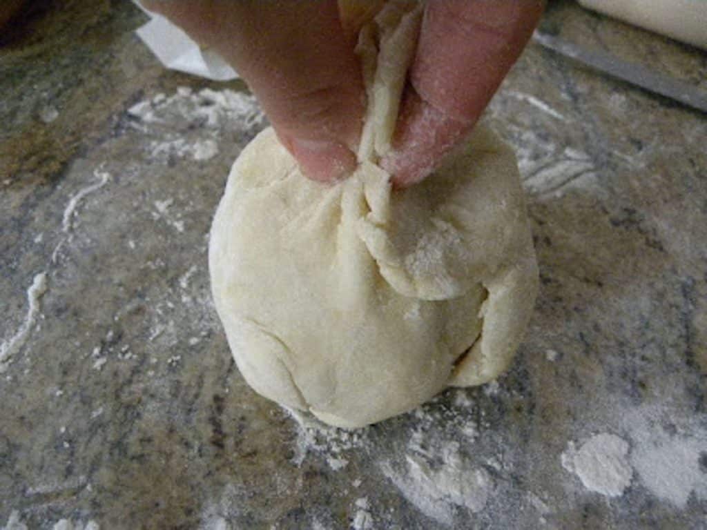 bringing the pastry dough up around the apple. 