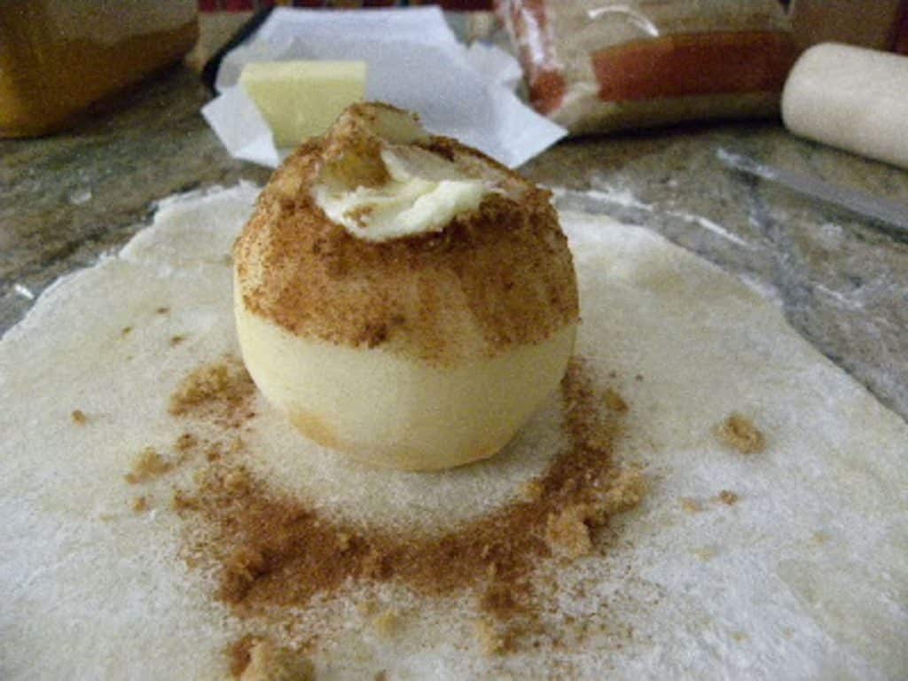 filling center of apple with brown sugar butter and cinnamon before wrapping it in the pastry dough