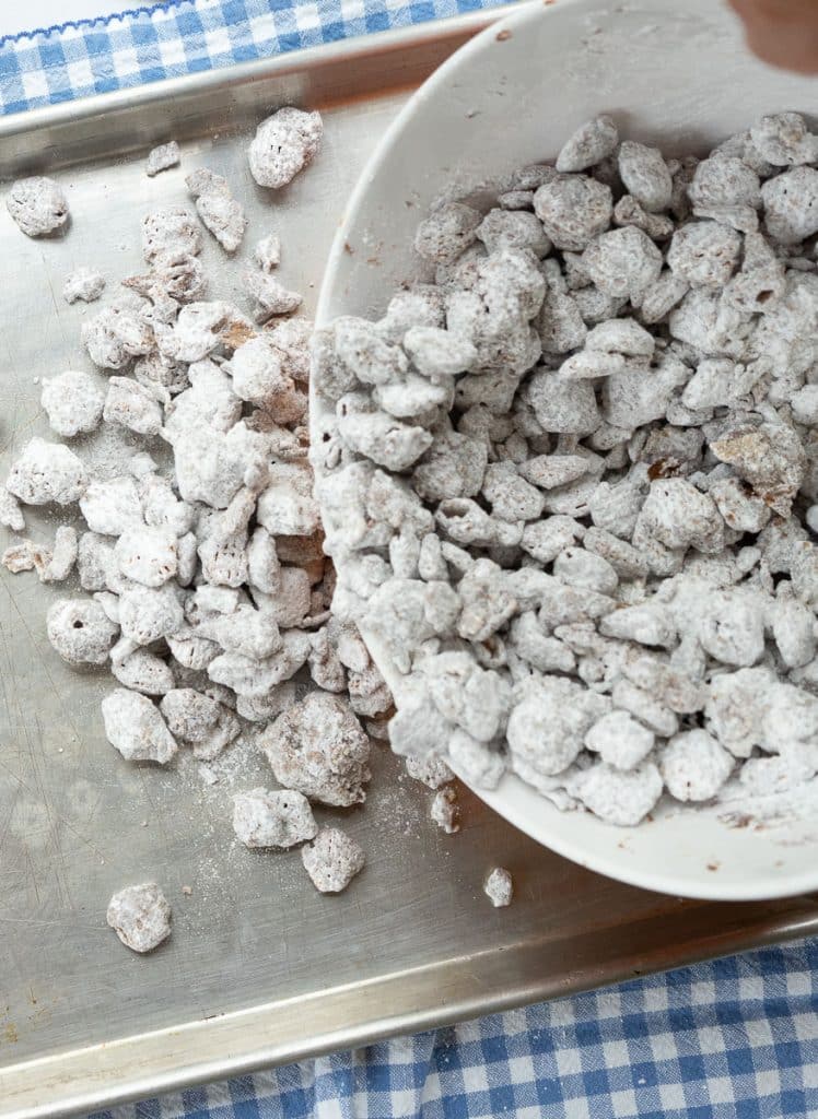 spreading puppy chow out on cookie sheet