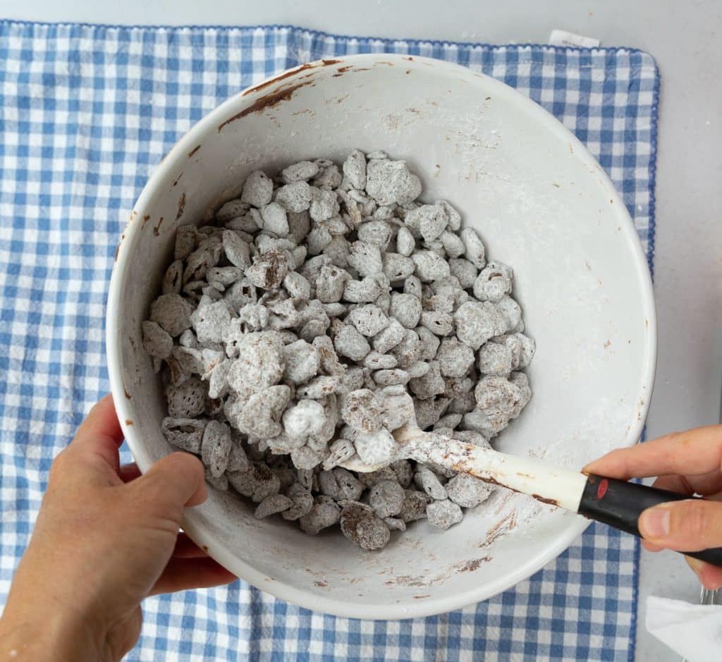stirring powdered sugar with into chocolate coated crispex cereal