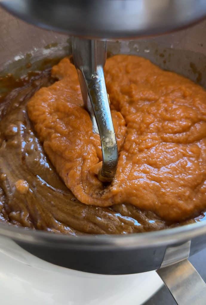 adding pumpkin mixture to mixing bowl