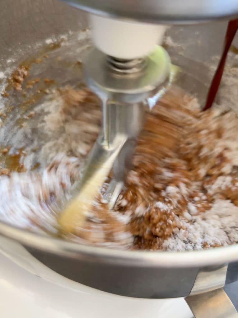 pouring molasses into dry ingredients