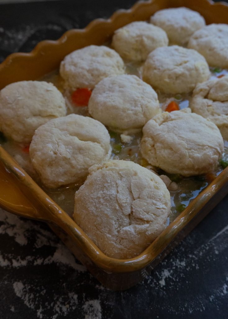unbaked chicken and biscuits in baking dish on countertop