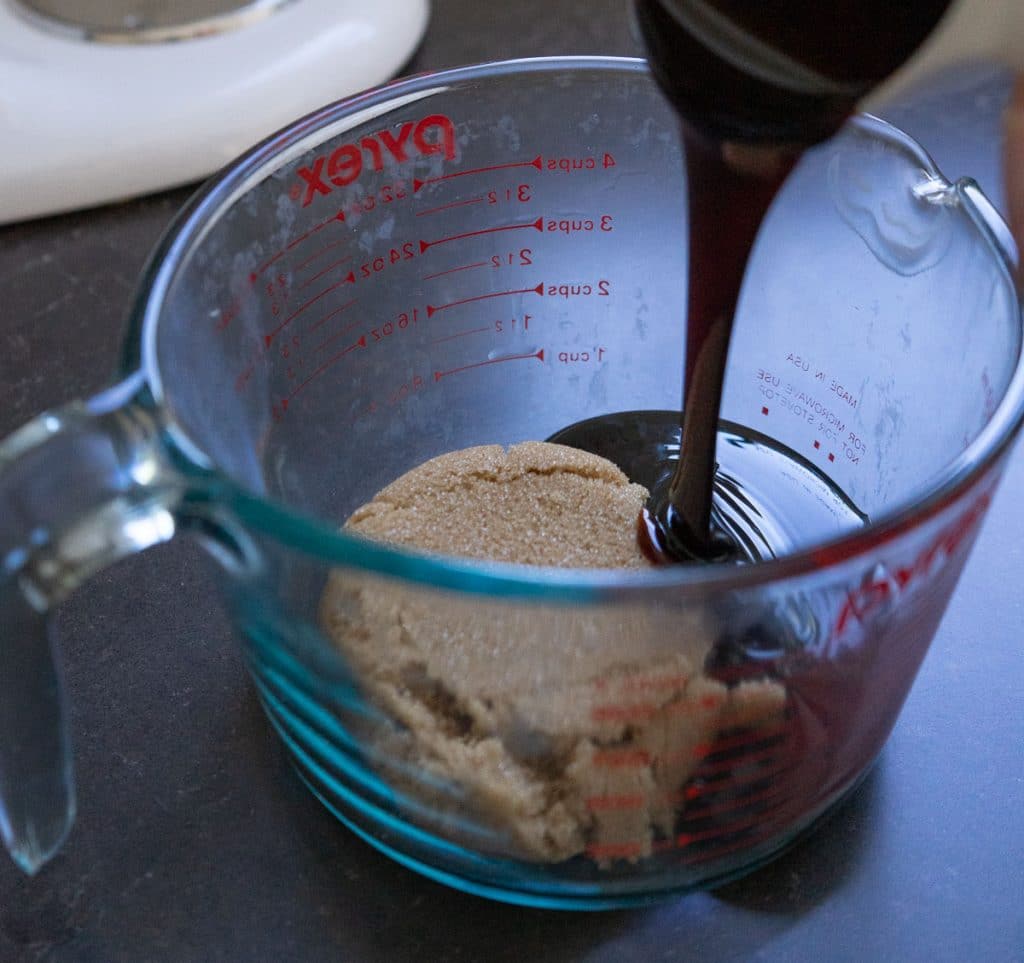 measuring ingredients into a large glass measuring cup