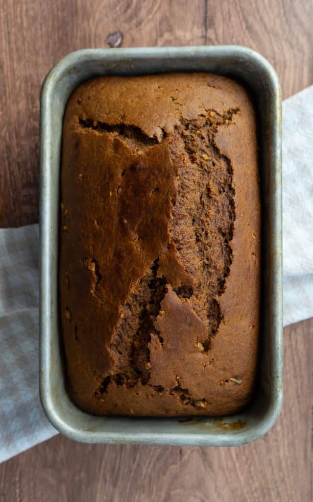 baked loaf of pumpkin gingerbread bread on a wood countertop . 