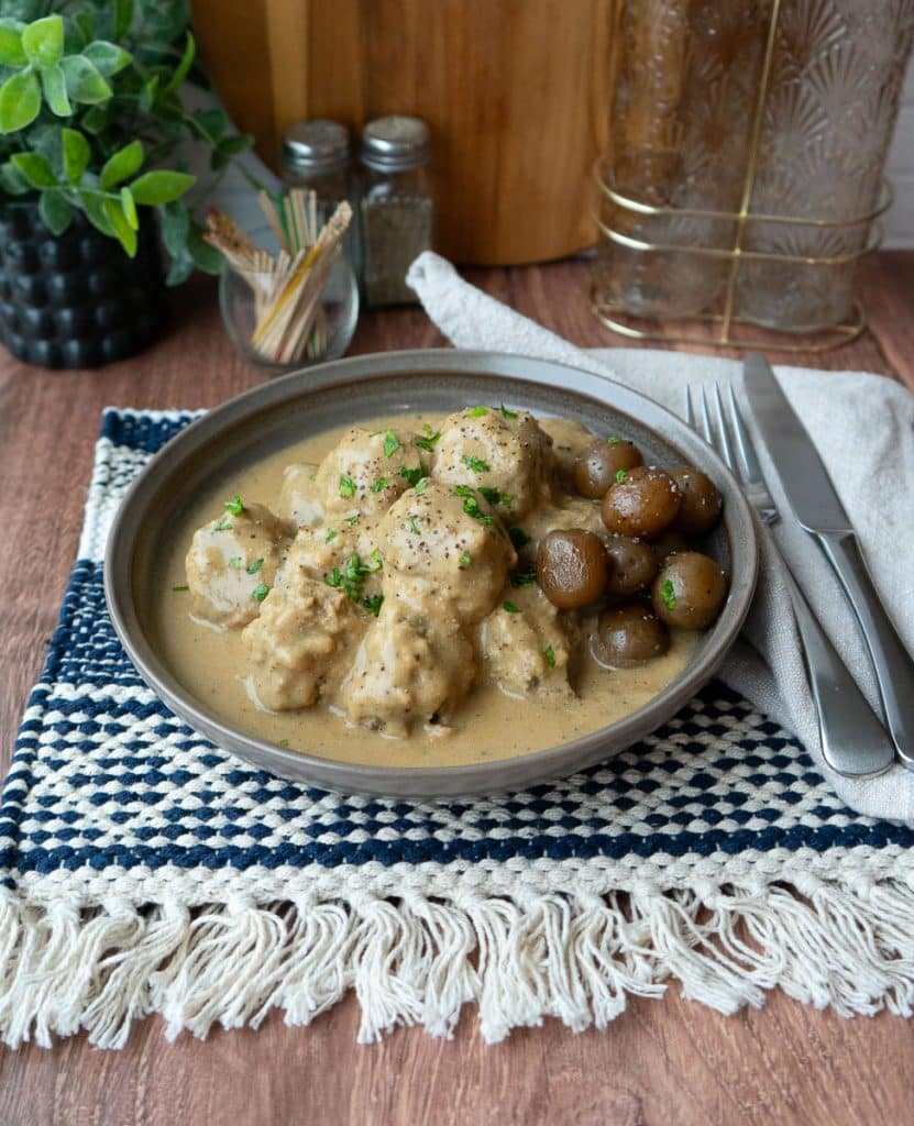 plate of swedish meatballs on a dinner table with a side of boiled potatoes