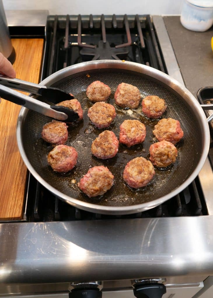 browning swedish meatballs in a large skillet on the stovetop