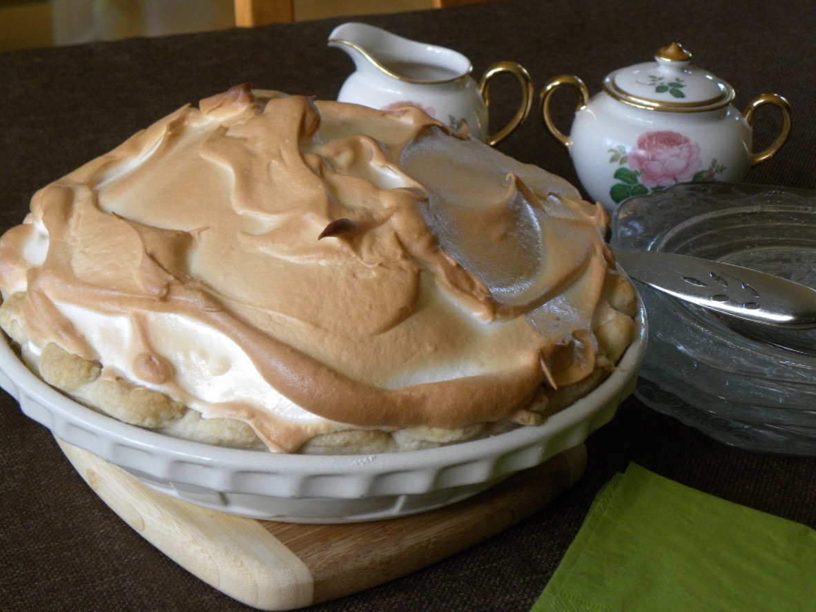 butterscotch pie sitting on table, pie is whole.