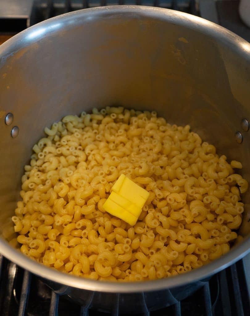 macaroni noodles in a pot with butter on top