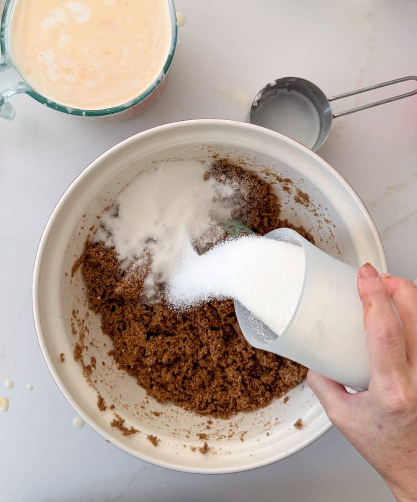 hand pouring sugar into bran from the lower right side of the photo