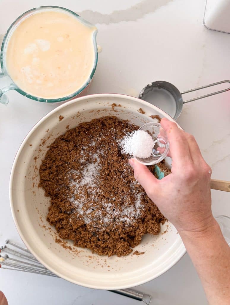 hand sprinkling salt over bran cereal in large bowl
