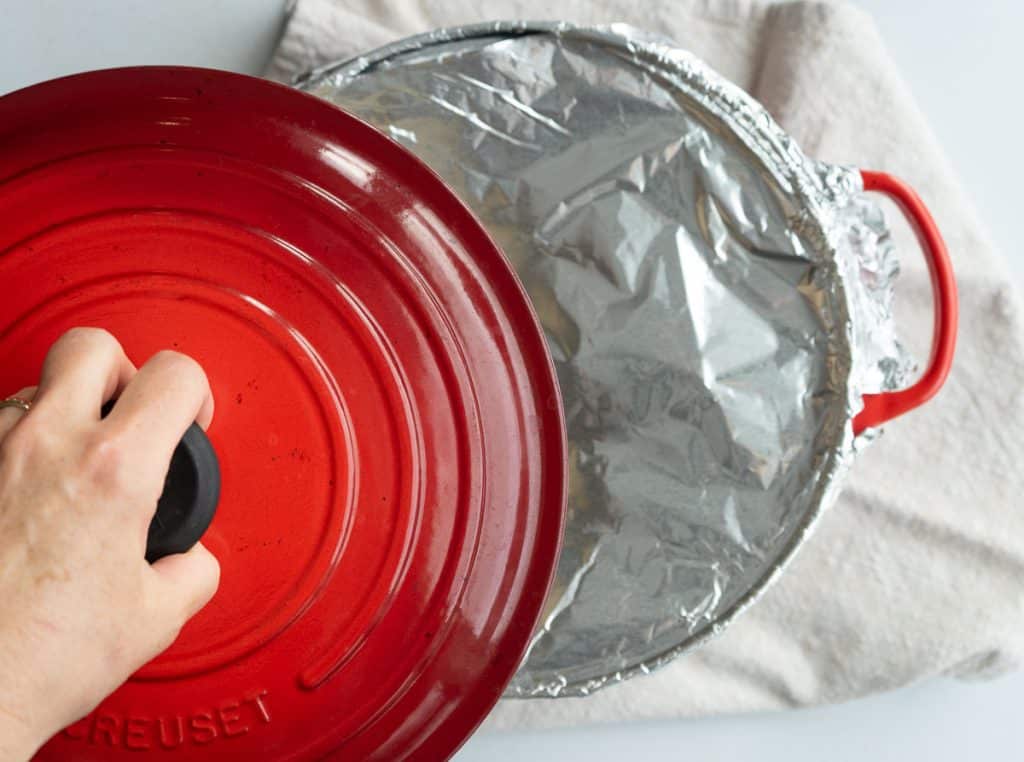 covering the dutch oven with aluminum foil and the lid