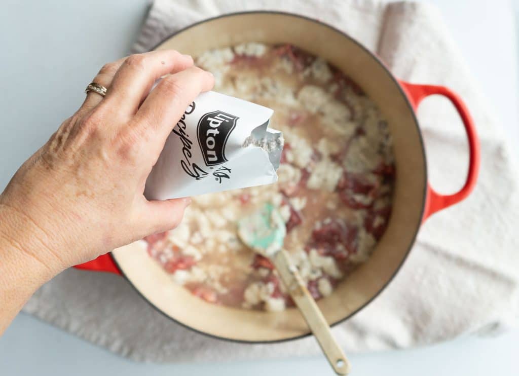 sprinkling a packet of onion soup mix over the top of the beef and other ingredients
