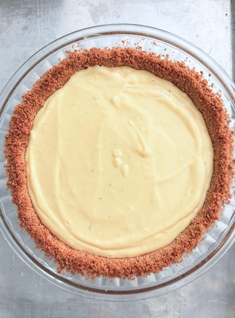 key lime pie with filling in the graham cracker crust before baking