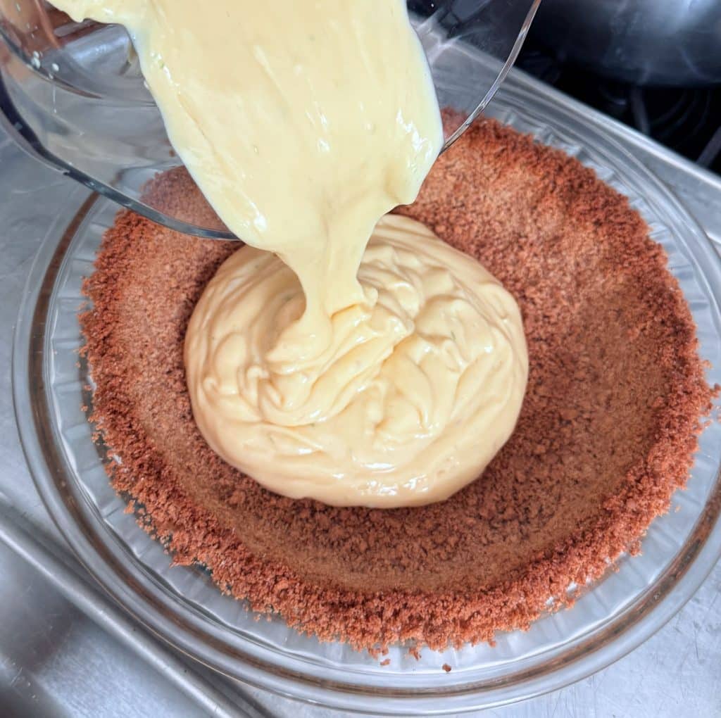 pouring the pie filling into the graham cracker crust