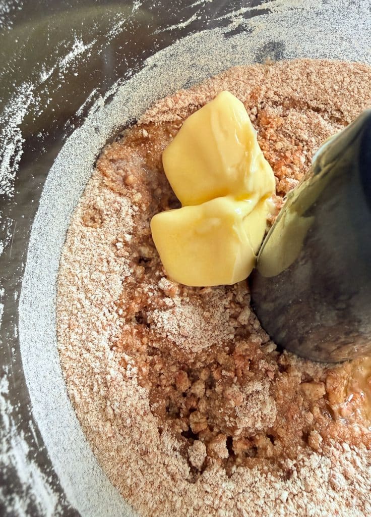 adding semi melted butter to the graham cracker crumbs and sugar