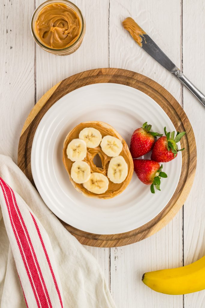 peanut butter honey spread on bagel with banana slices 