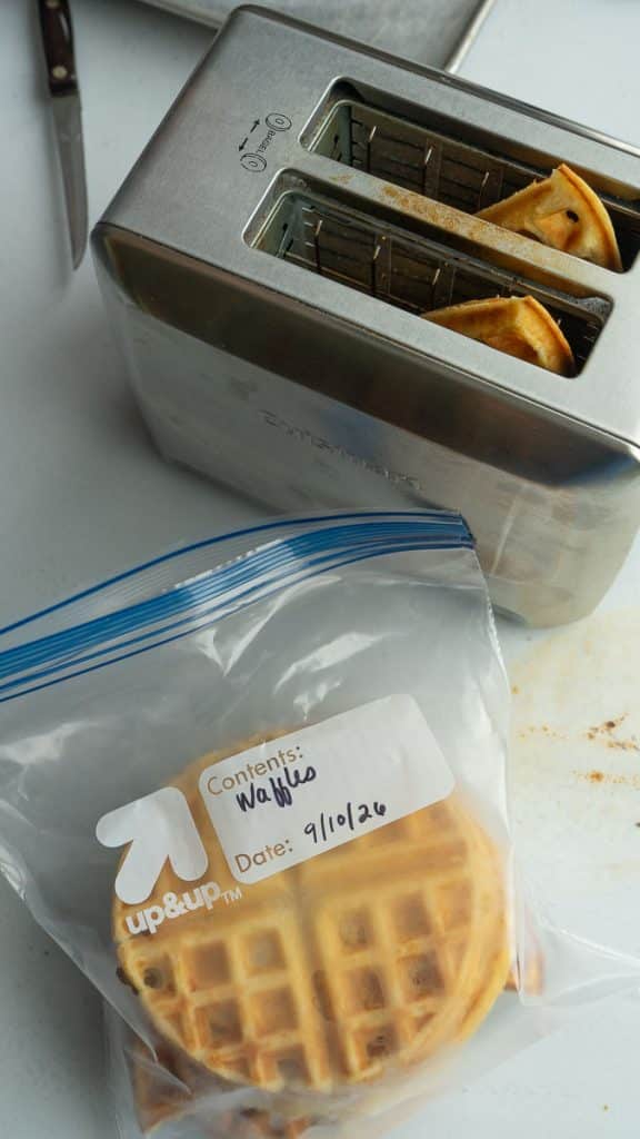 bag of frozen waffles next to a toaster with waffles in it