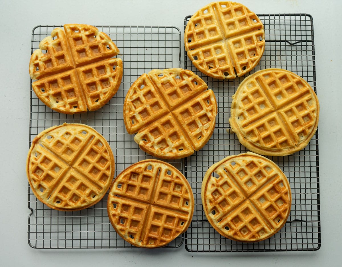 homemade waffles cooling on a wire rack on a white counter