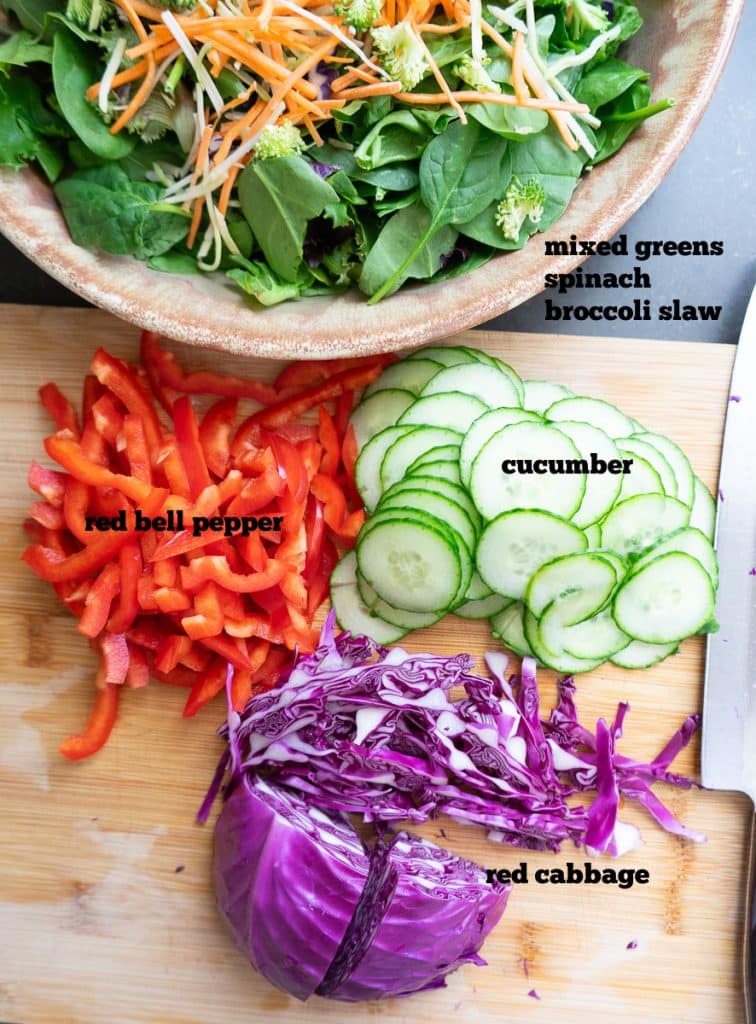 ingredient photo for tha salad. shows ingredients on a wood cutting board and in a salad bowl