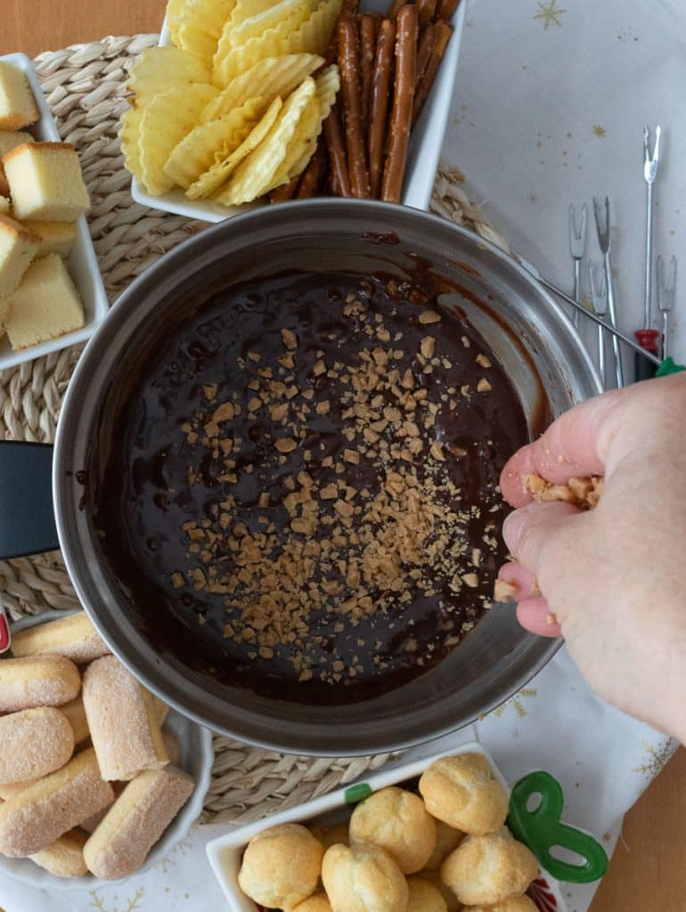 sprinkling toffee bits over chocolate toffee fondue